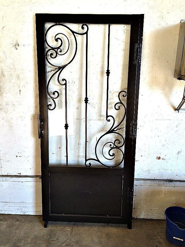 a wrought iron door is sitting in front of a white wall