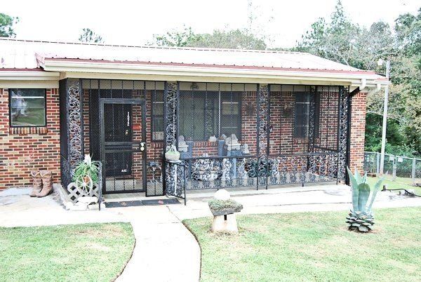 a brick house with a screened in porch and a walkway leading to it .