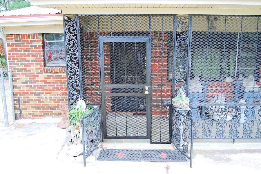 the front door of a brick house with a screen door