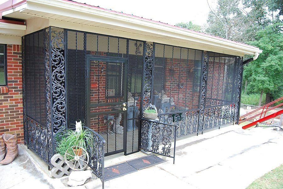 a brick house with a screened in porch and a ramp