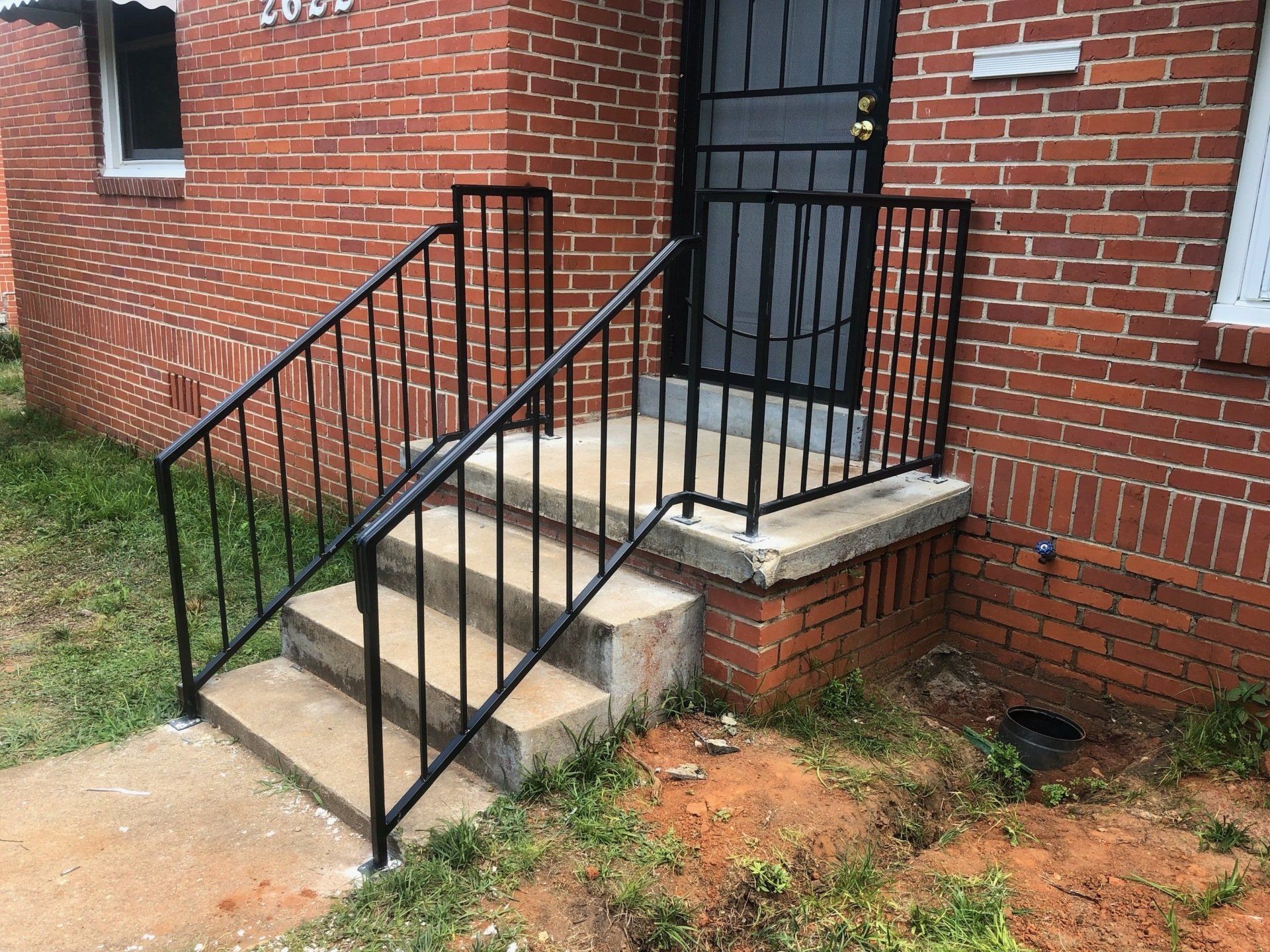 a brick building with stairs and a metal railing .