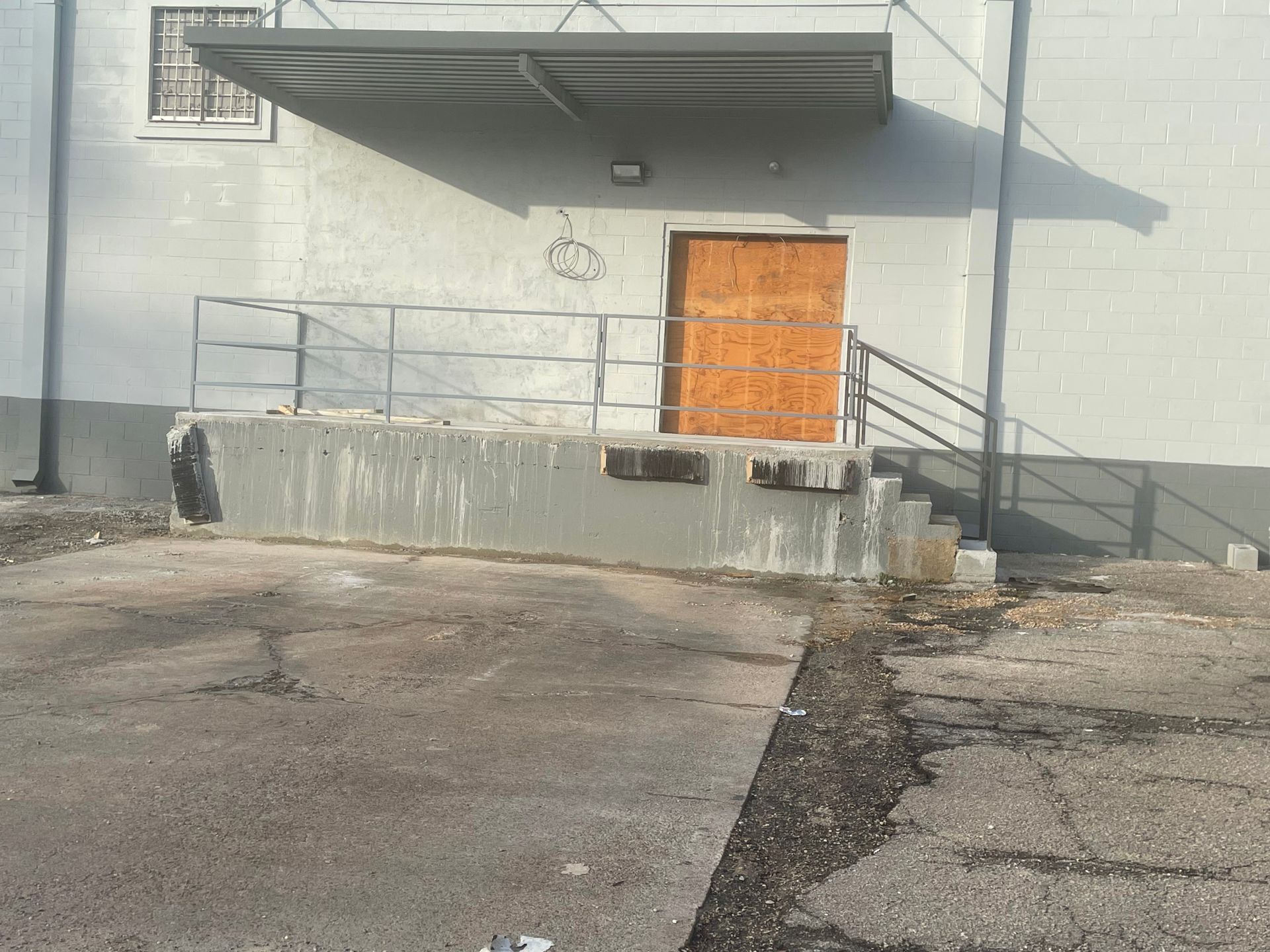 a white building with a wooden door and stairs