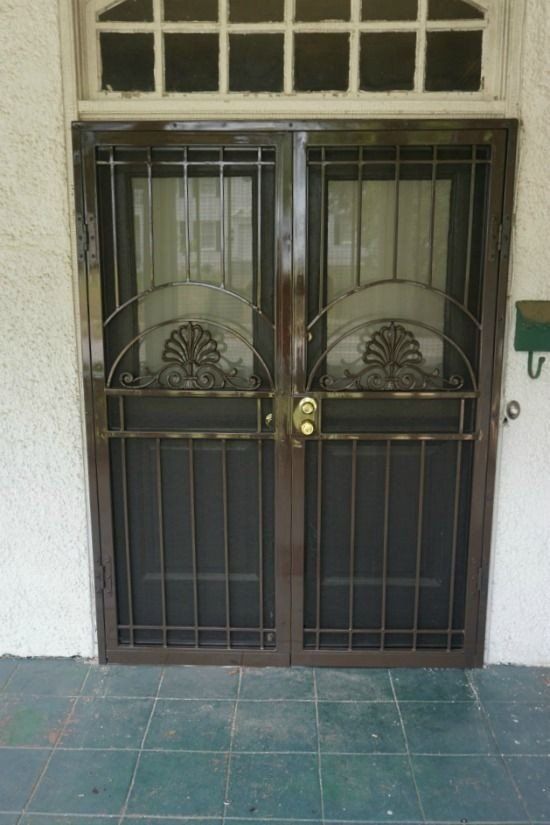 a door with a screen on it is sitting on a tiled floor next to a mailbox .