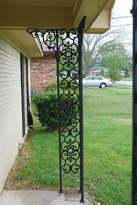 a wrought iron porch with a car parked in the background .