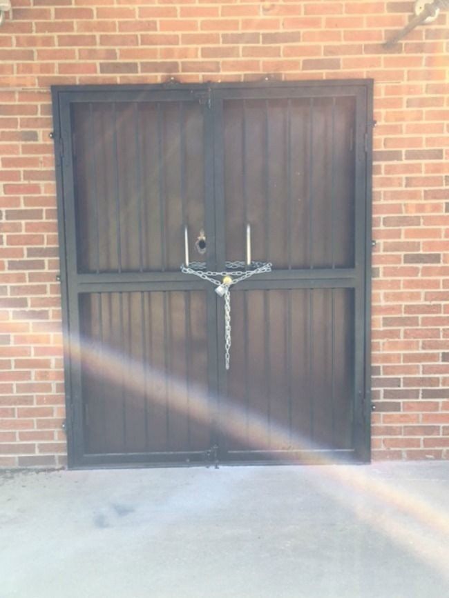 a brick building with a wooden door locked with chains