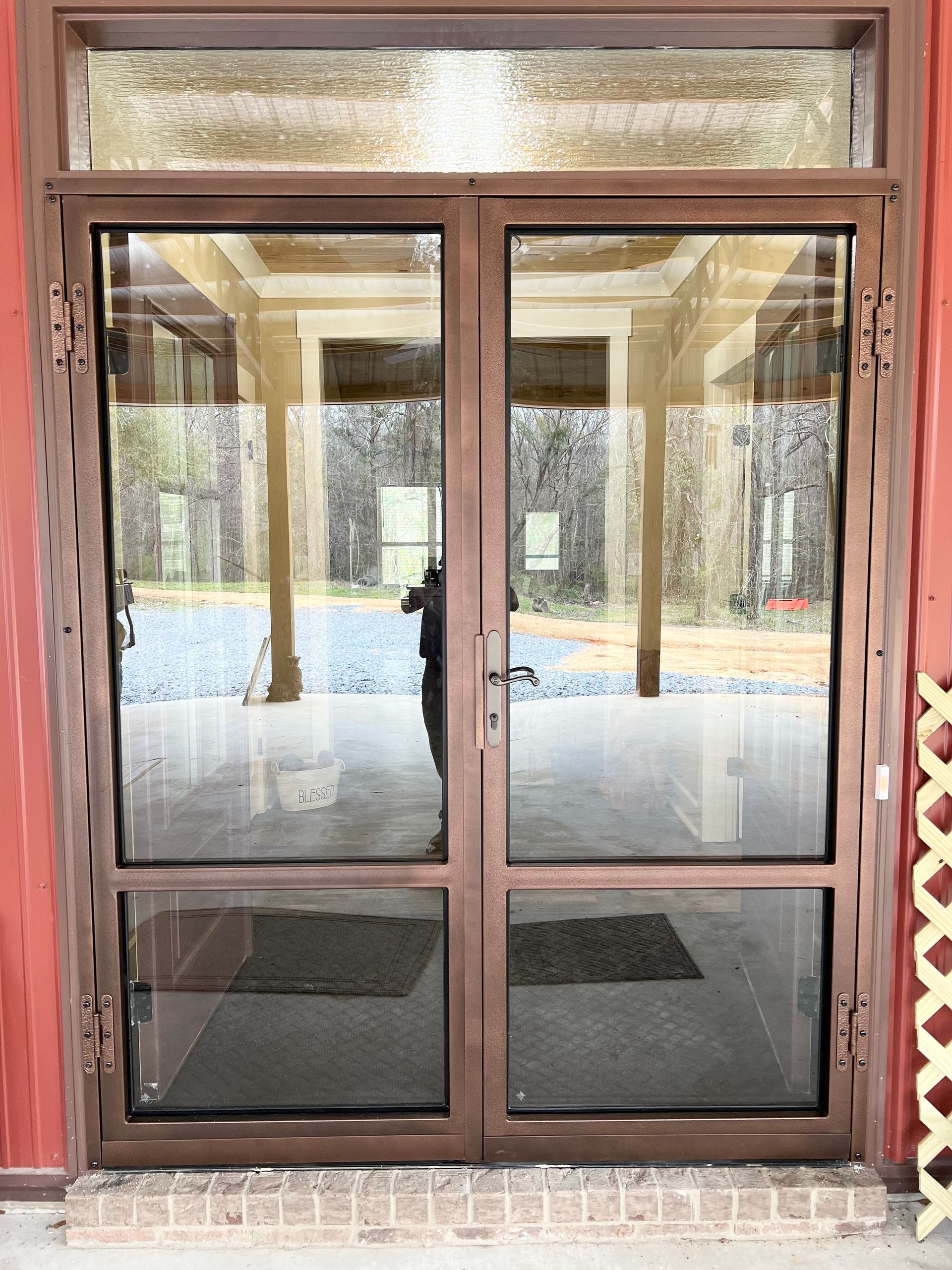 a door with a lot of glass is open to a building .