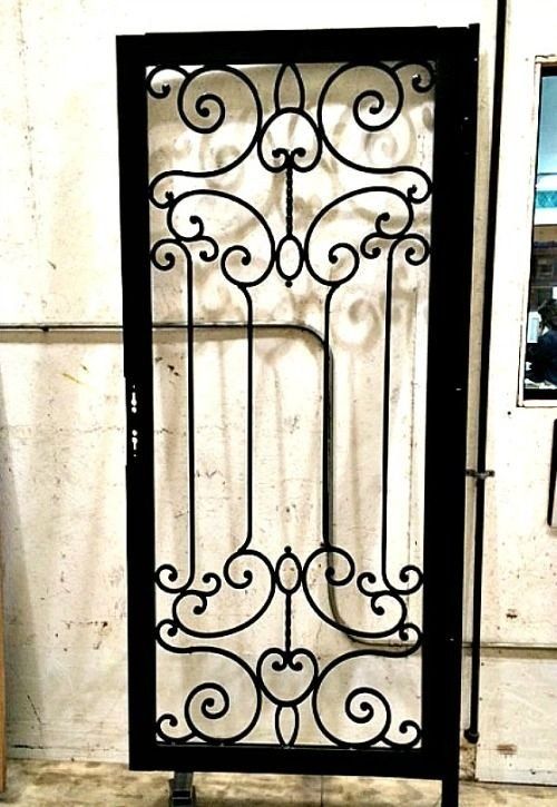 a wrought iron gate is sitting in front of a white wall .