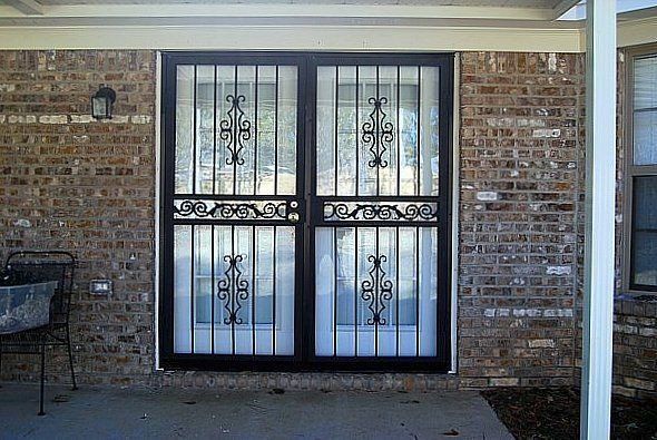 a brick house with a wrought iron gate on the front door