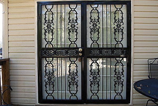 a wrought iron door is on the side of a house .