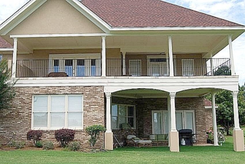 a large brick house with a large porch and balconies