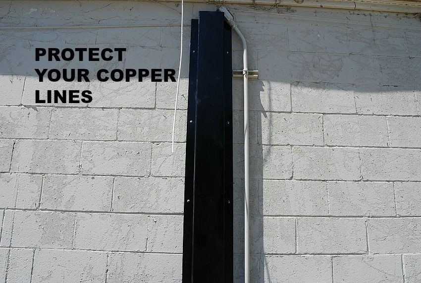 a sign on a brick wall that says protect your copper lines