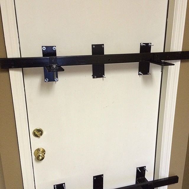 a white door with a gold door knob and a black bar on it