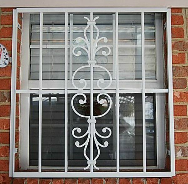 a window with a wrought iron grill on it is on a brick wall .