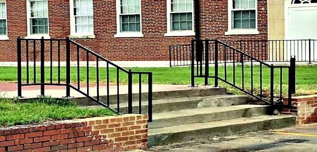a brick building with stairs and a railing in front of it .