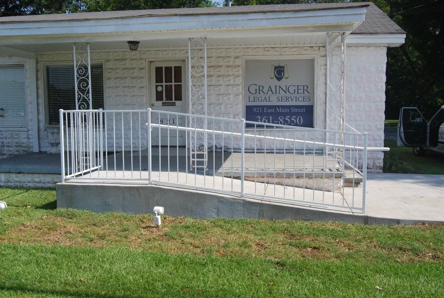 a white brick building with a ramp and a sign that says grainger
