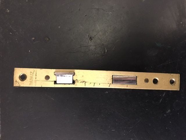 a piece of brass is sitting on a black surface .