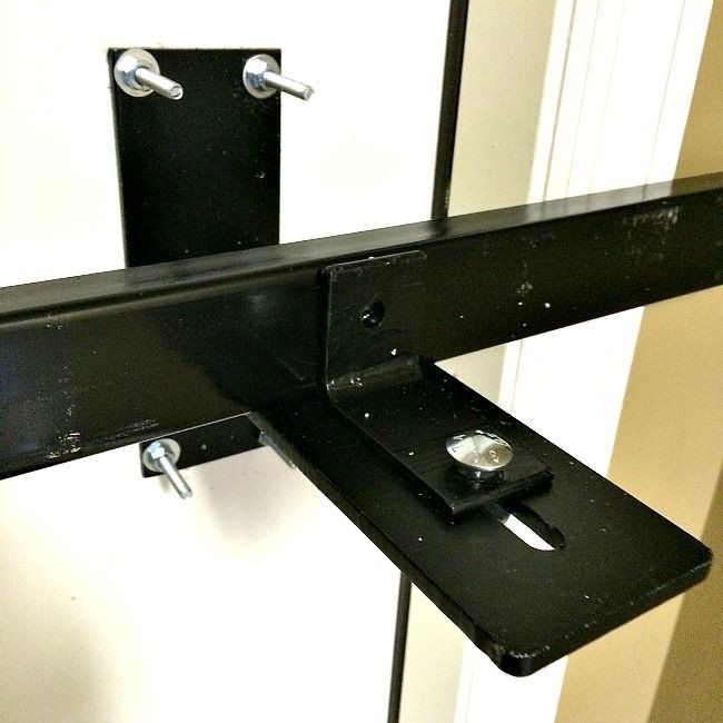 a black metal bracket with two screws attached to it