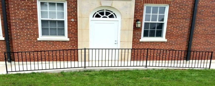 a brick building with a white door and a black railing
