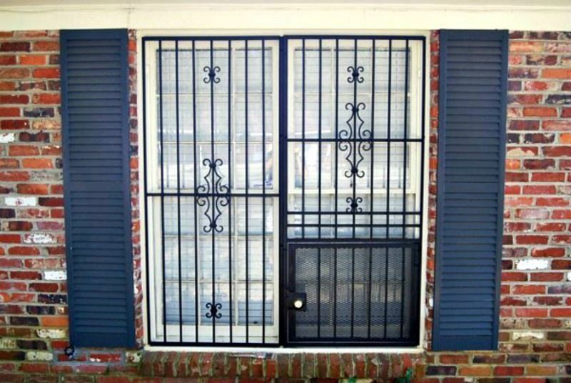 a window with blue shutters and a wrought iron gate