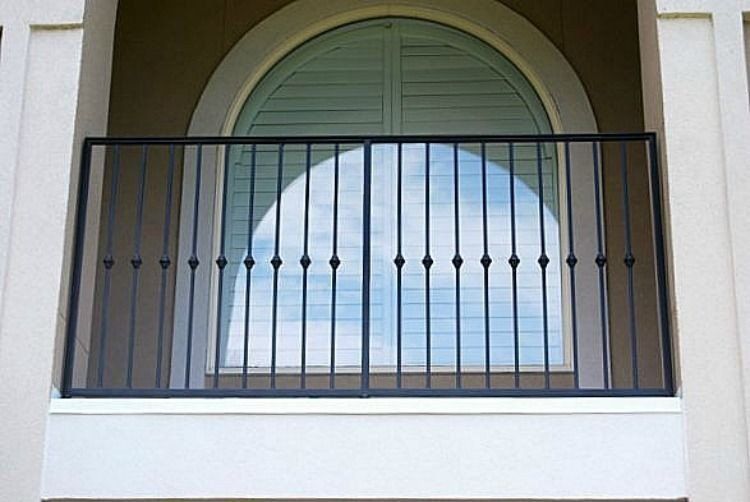 a balcony with a wrought iron railing and a large window .