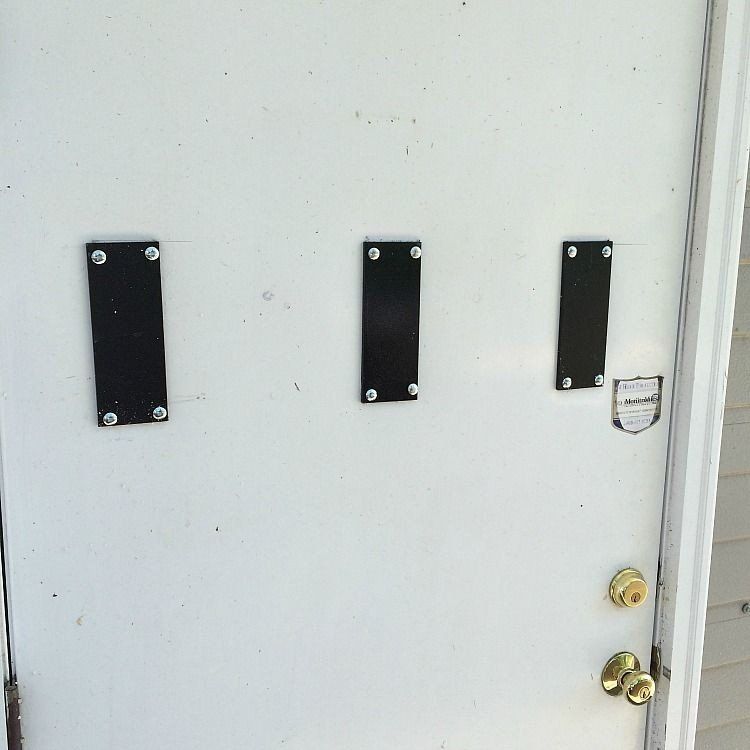 a white door with three black plaques on it