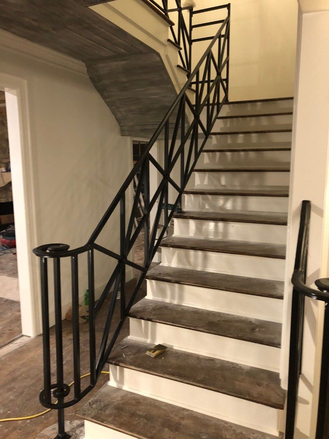 a staircase with a black railing in a house .