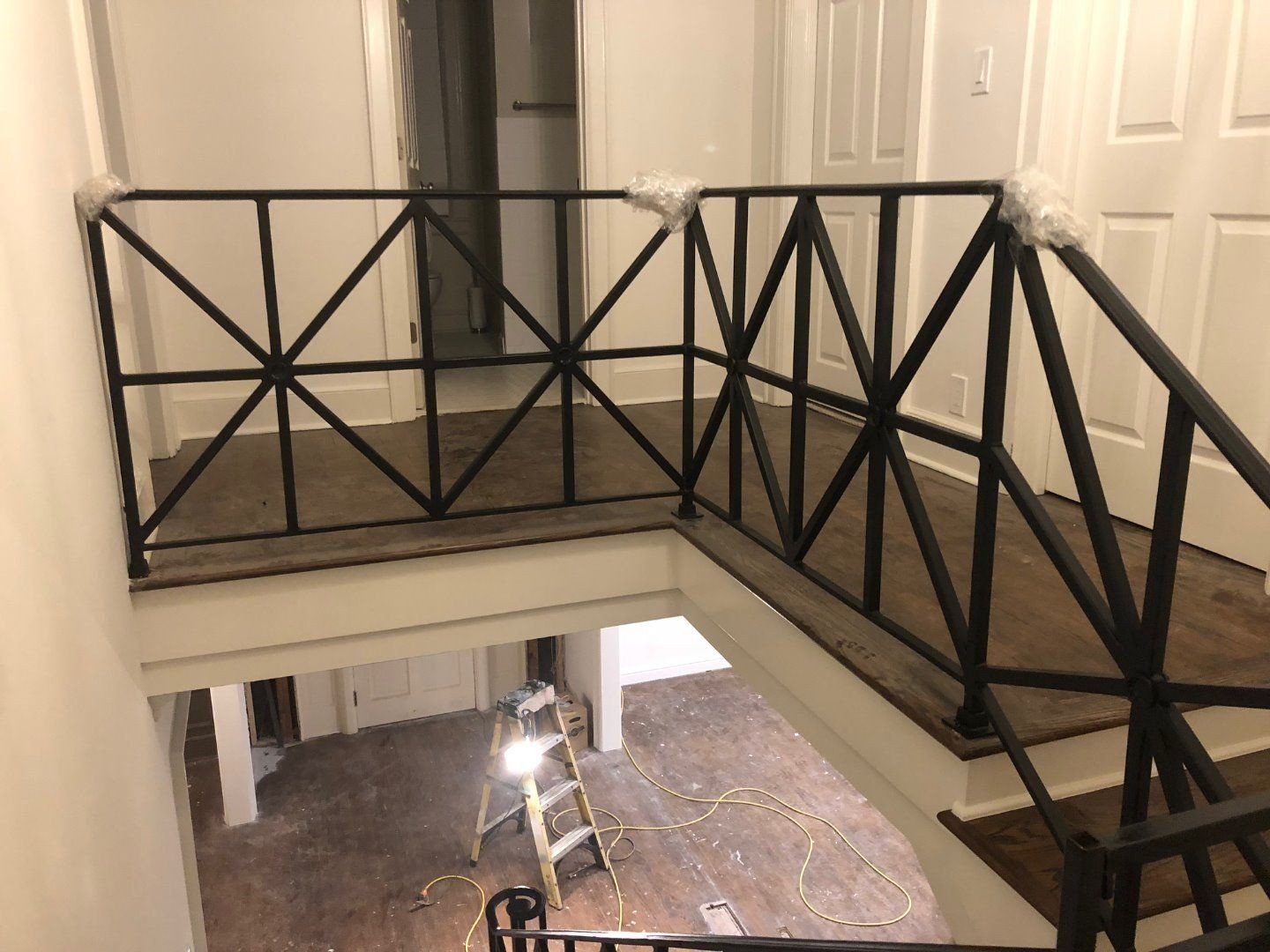 a staircase with a metal railing in a house under construction .