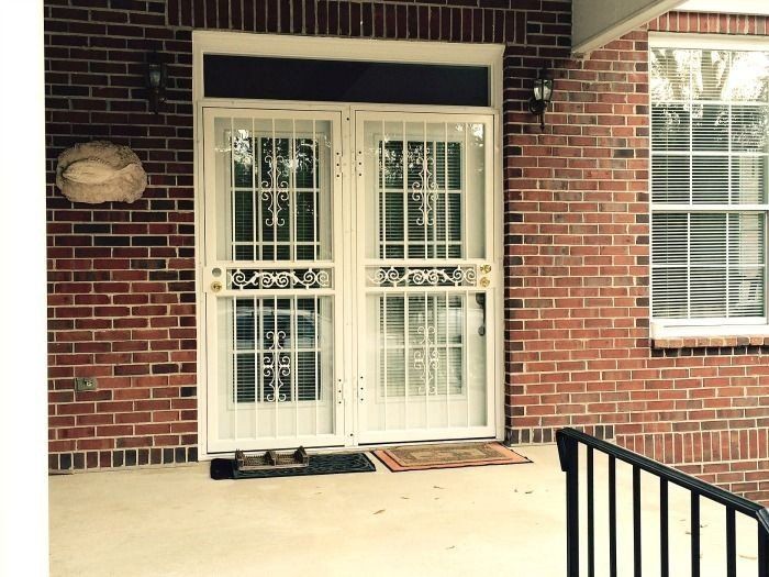 a brick house with a white door and a black railing