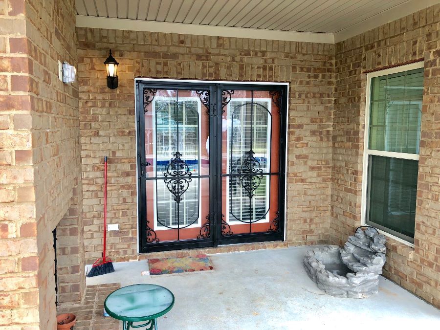 a brick house with sliding glass doors and a table