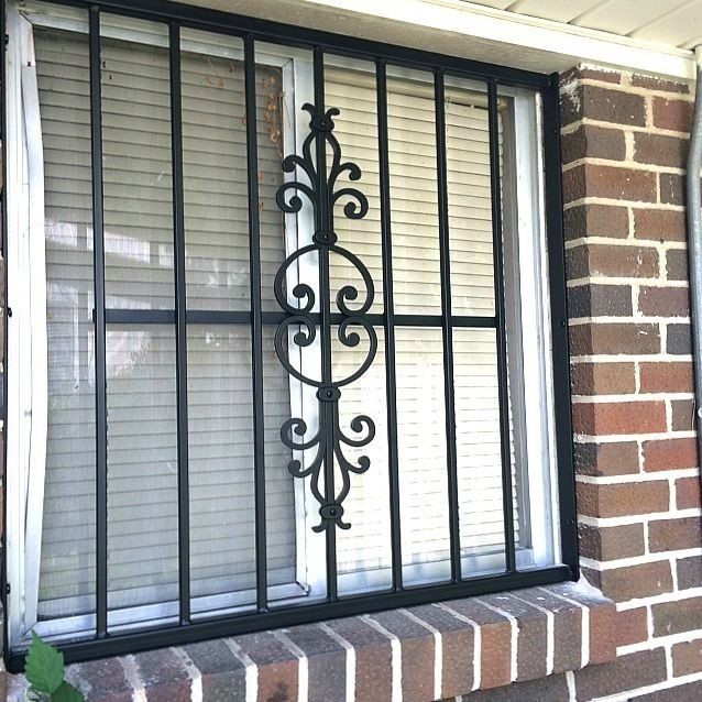 a window with a wrought iron grill on it is on a brick wall .