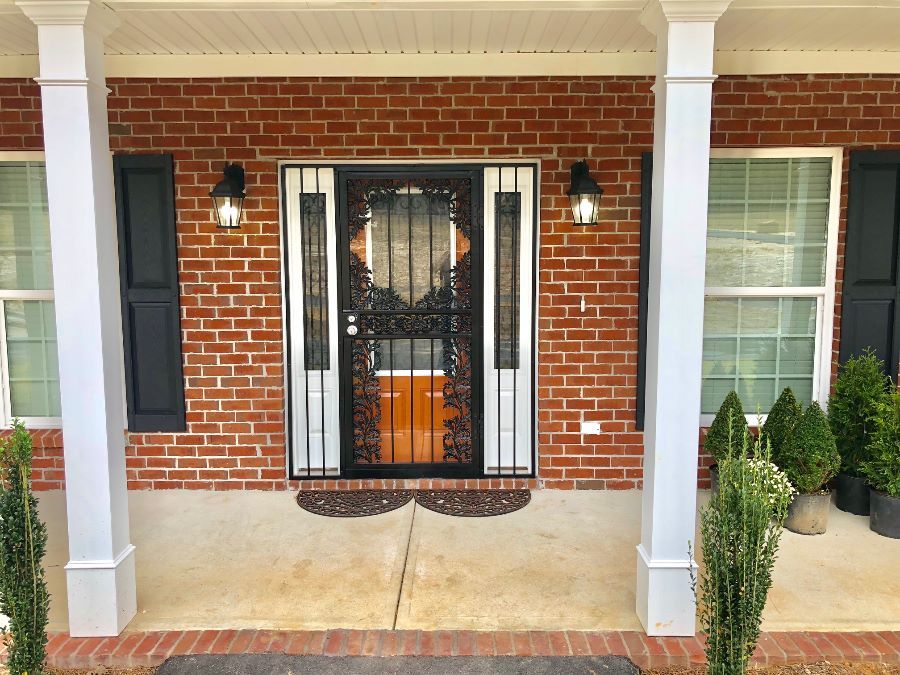 a brick house with a porch and a black door
