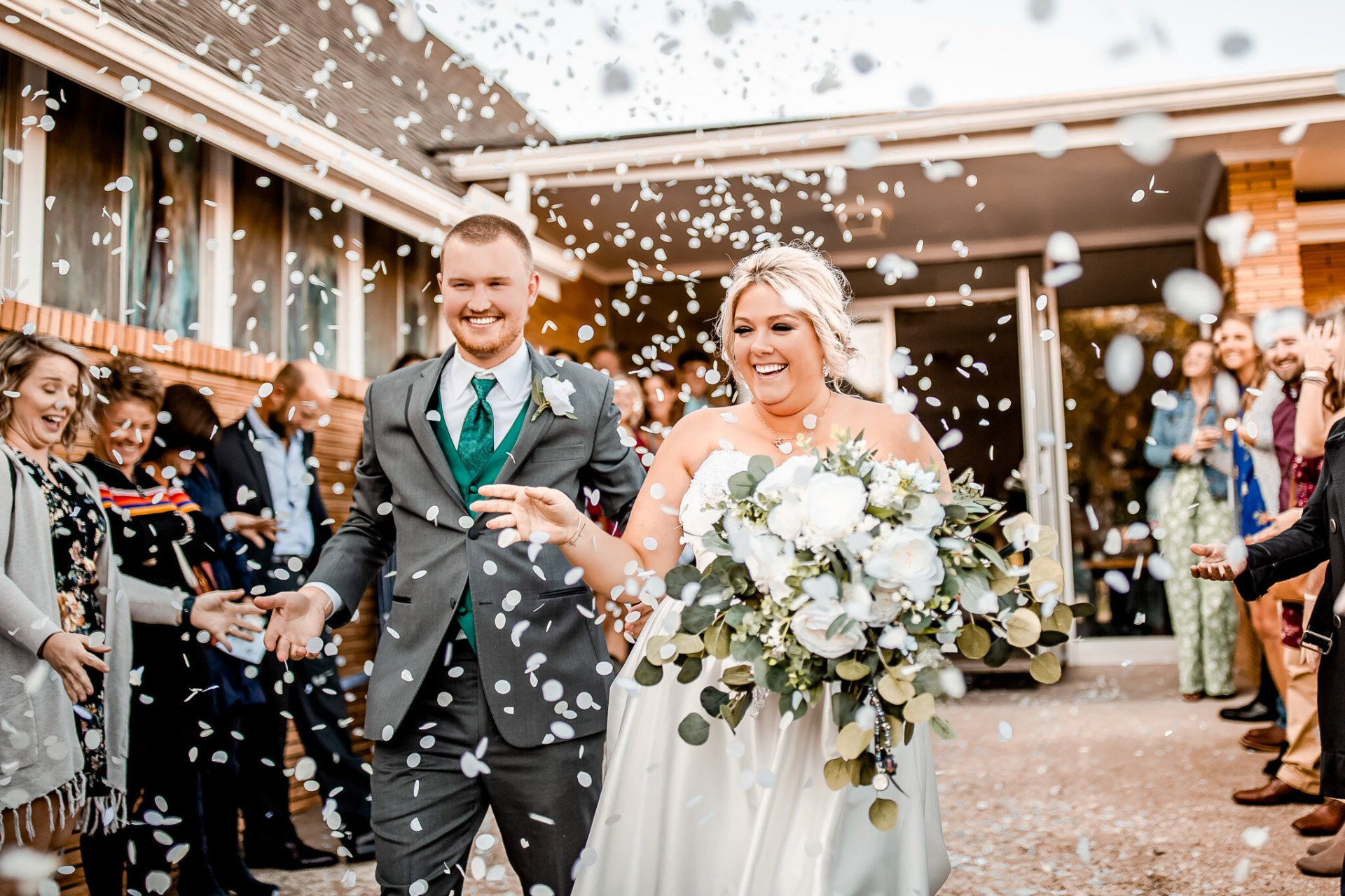Wedding ceremony: Couple dips, smiling. Groom holds bride, officiant smiles, background decorated.