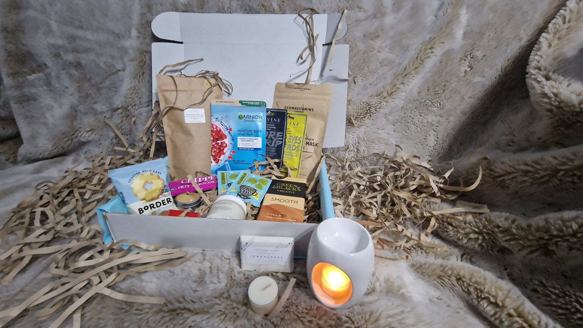A box filled with a variety of items and a candle.