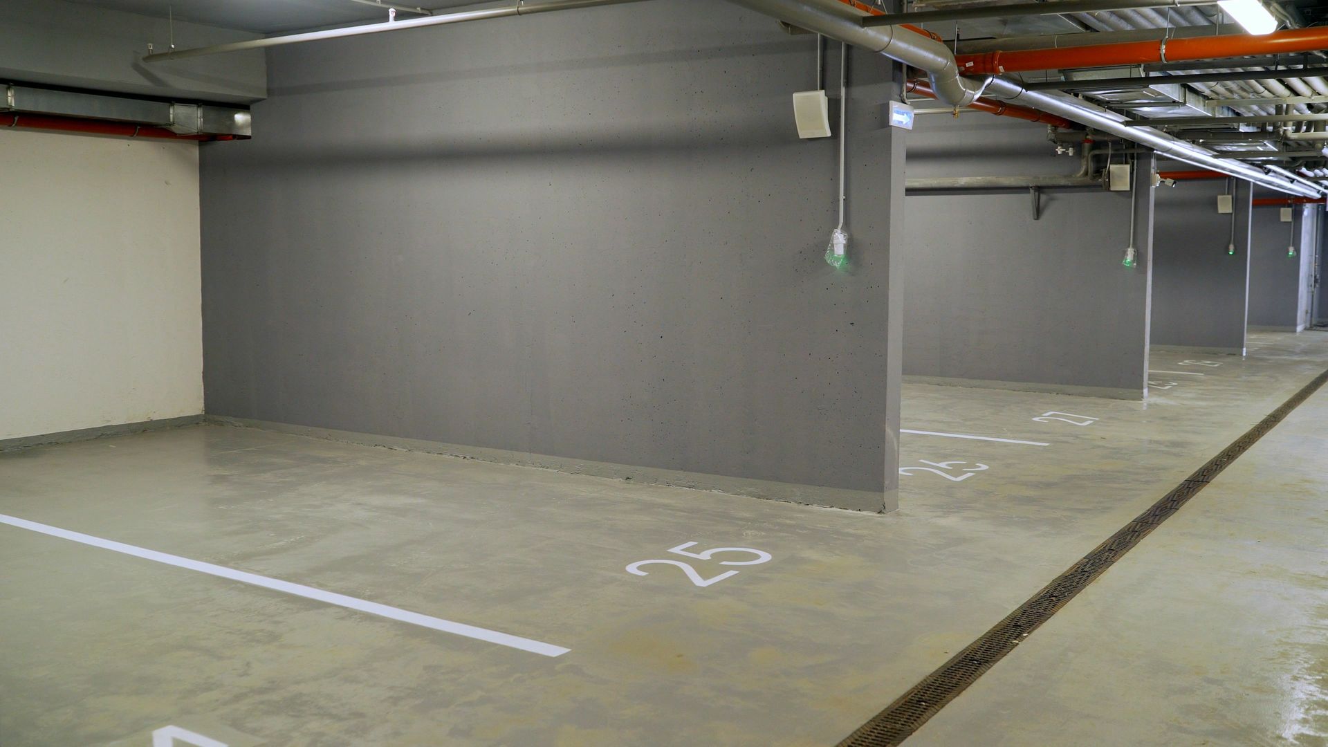 An empty underground parking garage with a handicapped parking space.