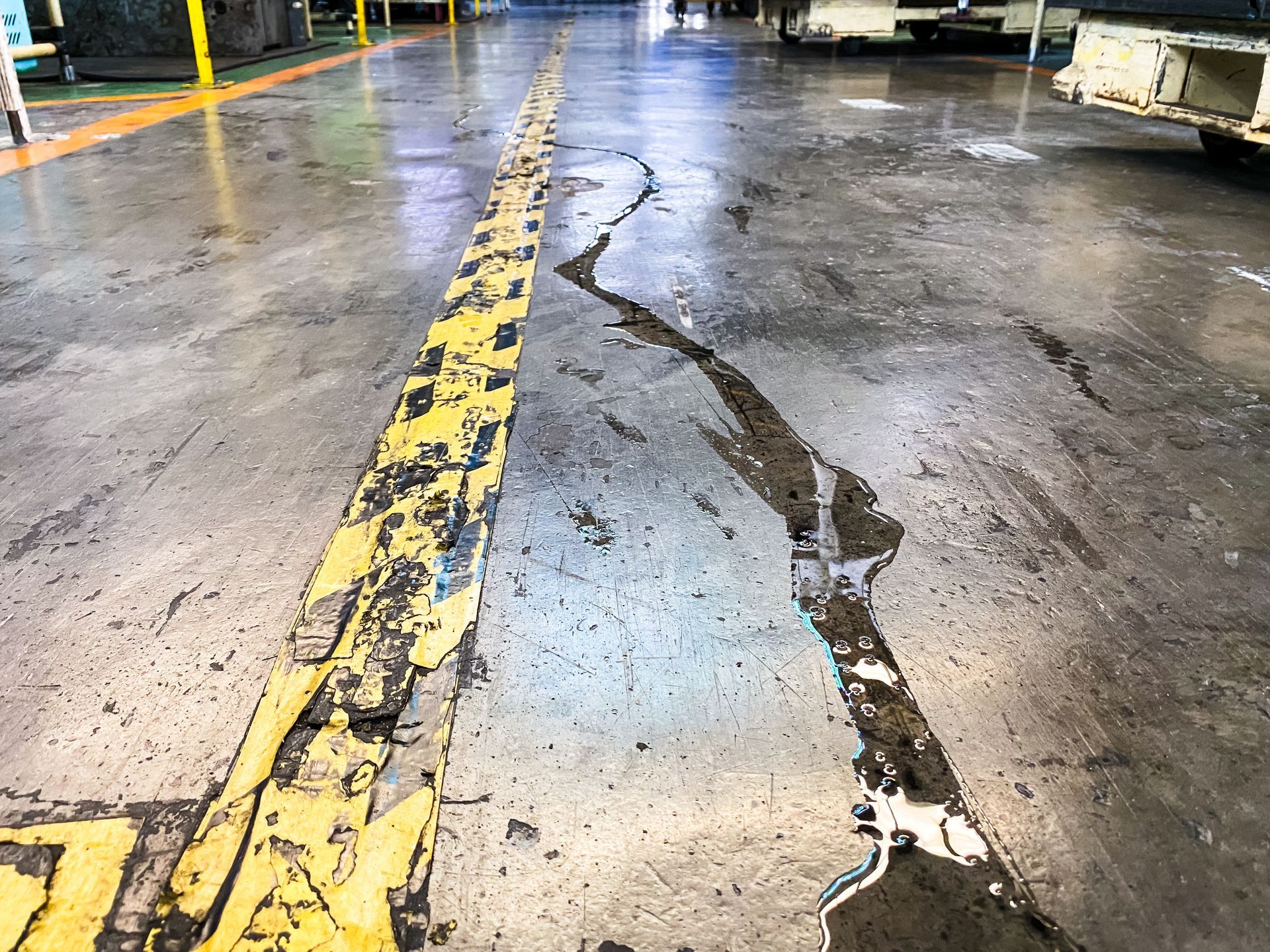 A dirty concrete floor with a yellow line on it.