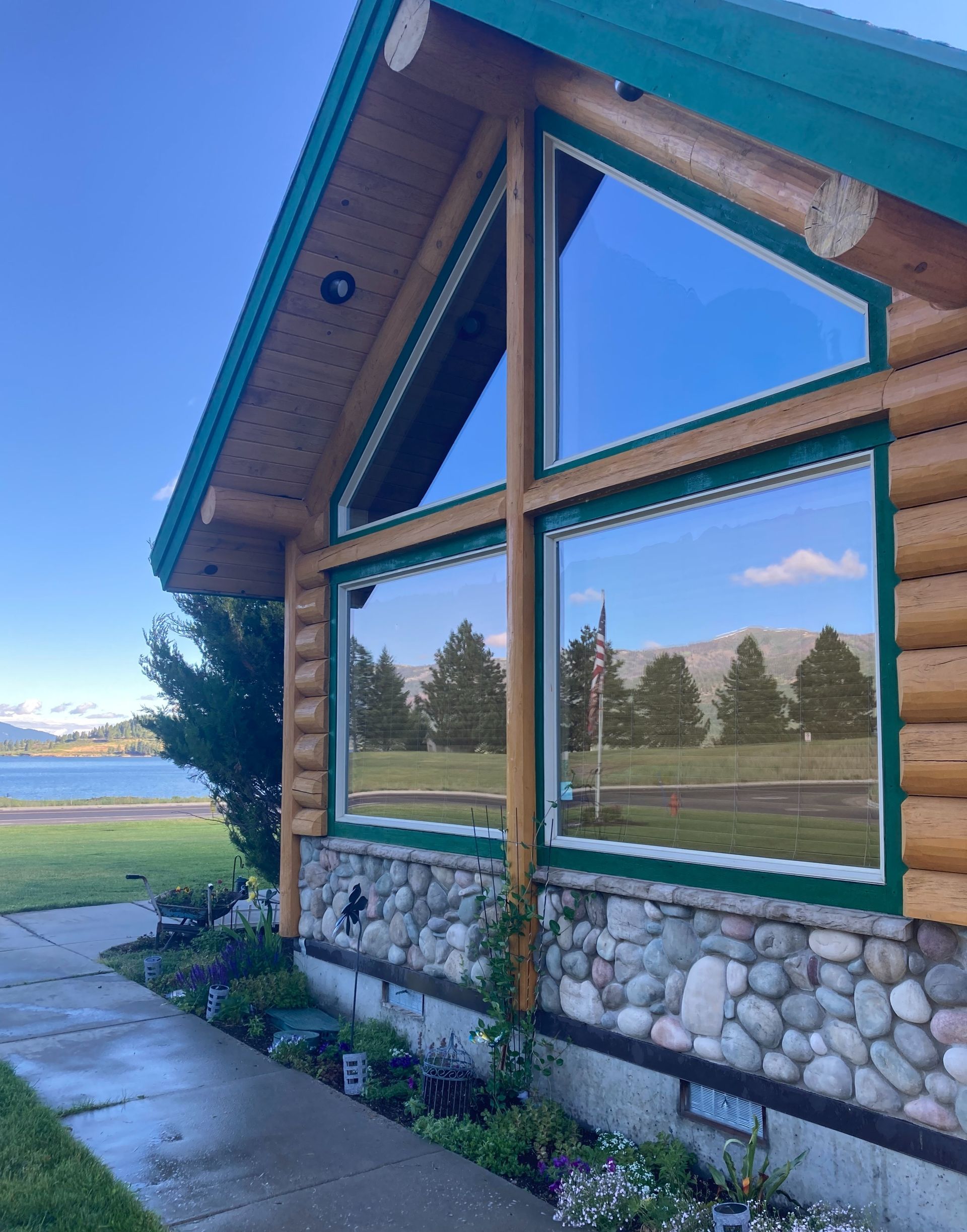 A log cabin with a green roof and lots of windows