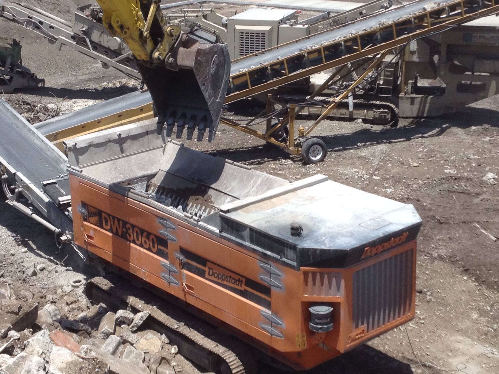 A person is holding a shovel filled with bricks and a bag of bricks.