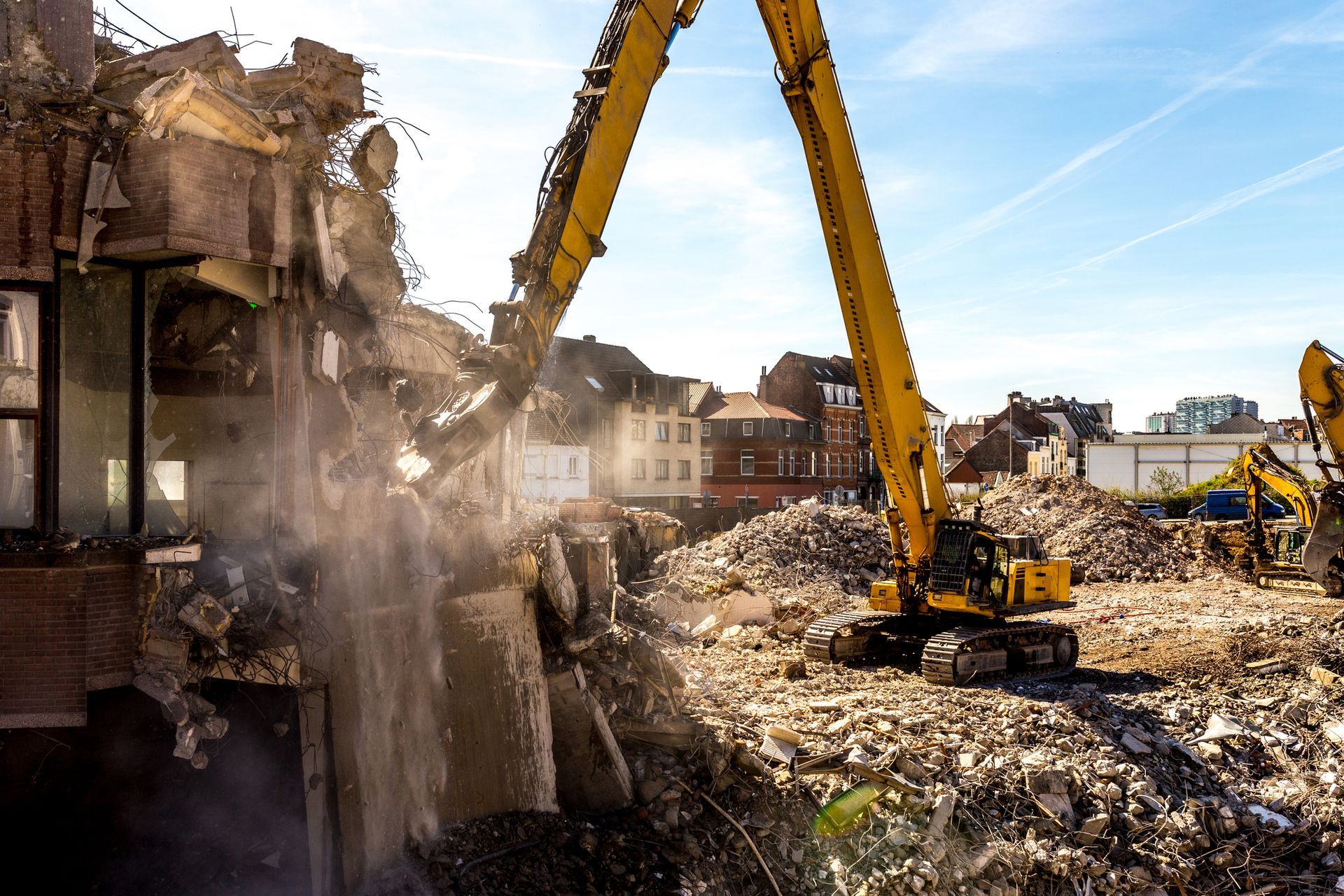 Demolition of a building in progress using a large excavator machine at a construction site.