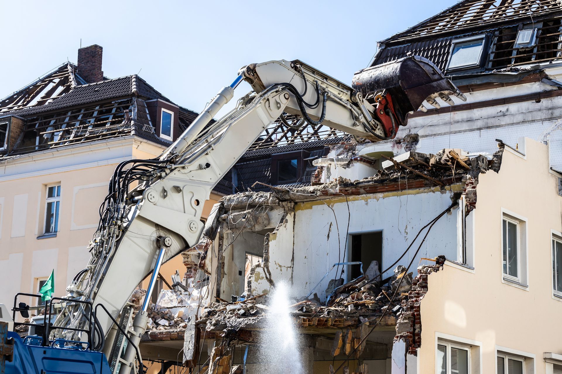 An excavator is demolishing a building in a city.