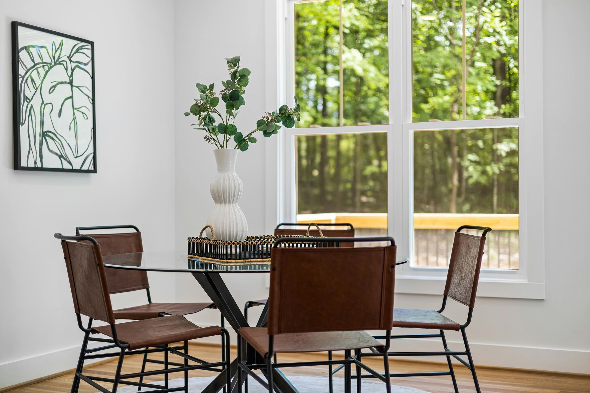 A dining room with a table and chairs and a window.