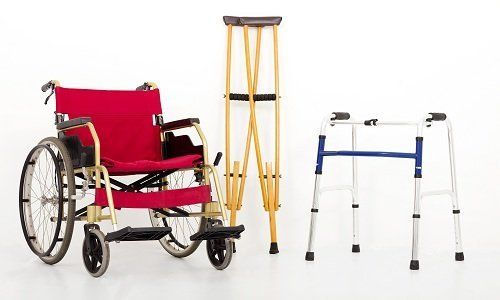 una sedia a rotelle dei ,bastoni canadesi e un deambulatore