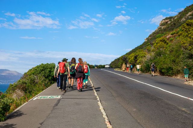 A group of people are walking down a road.