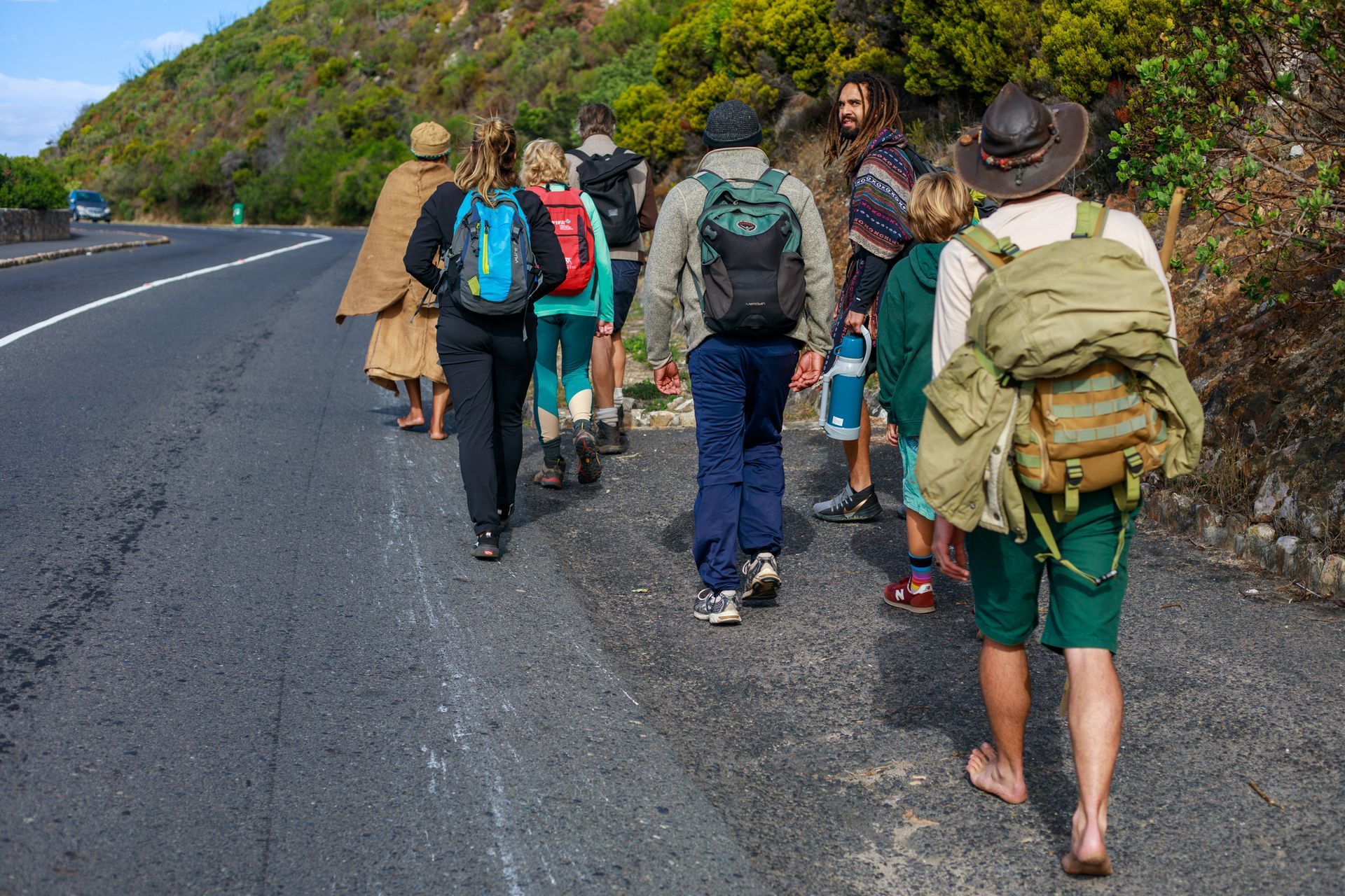 A group of people are walking down a road.