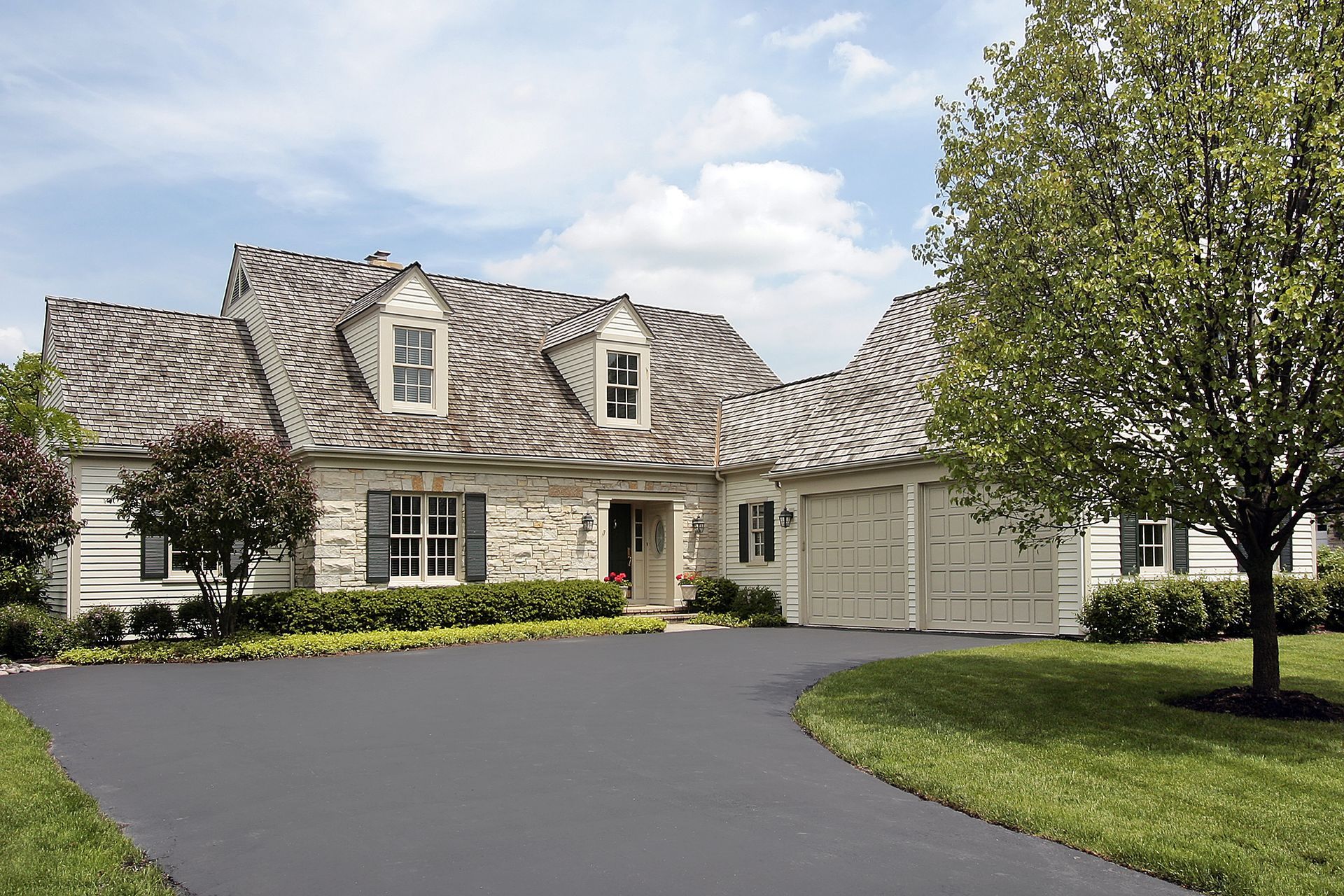 Picture of a house and connected garage with cedar shake roofing