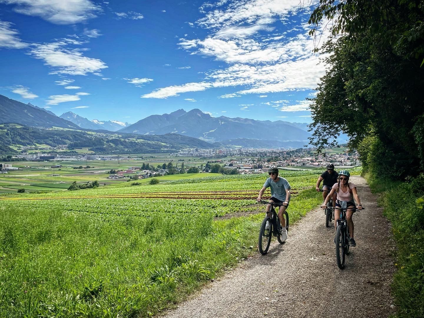 A group of people are riding bicycles down a dirt road.