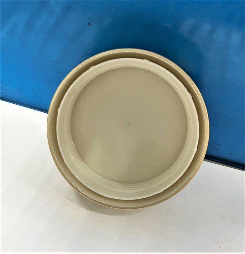 A white plastic lid is sitting on a white surface