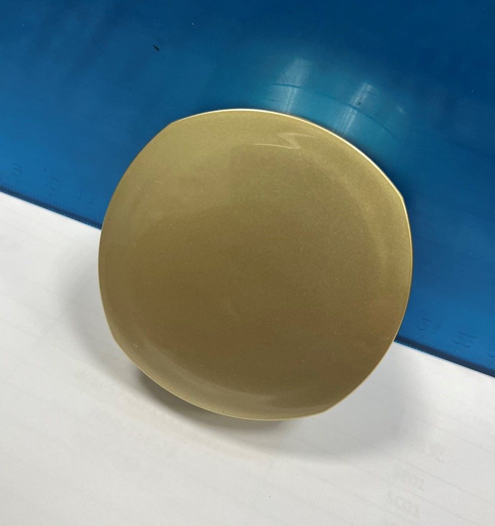 A round object is sitting on a white surface in front of a blue wall