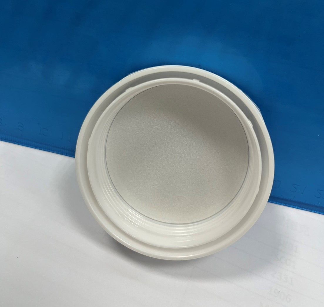 A white bowl is sitting on a white surface with a blue background