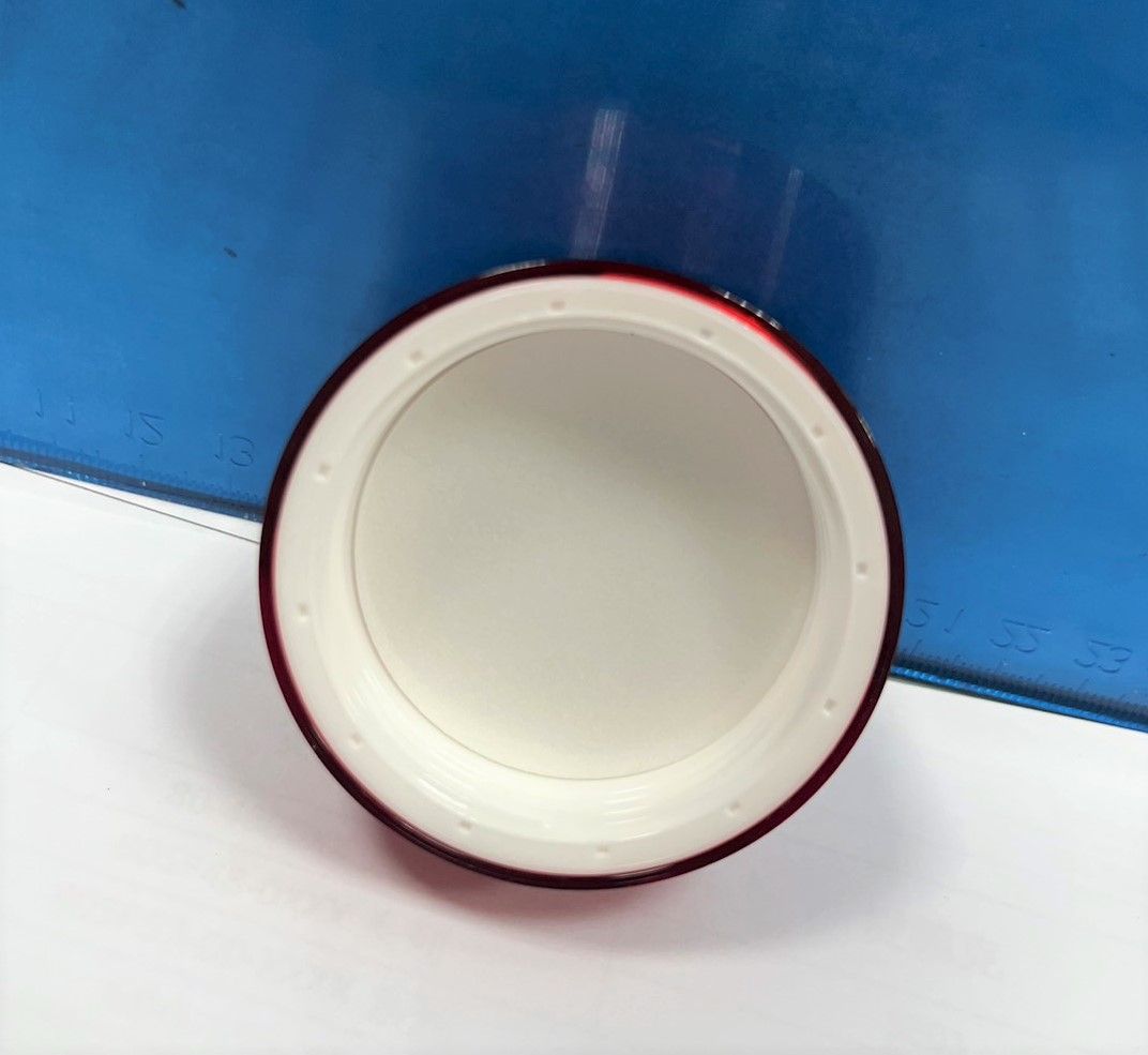 A white circle with a red rim sits on a white surface