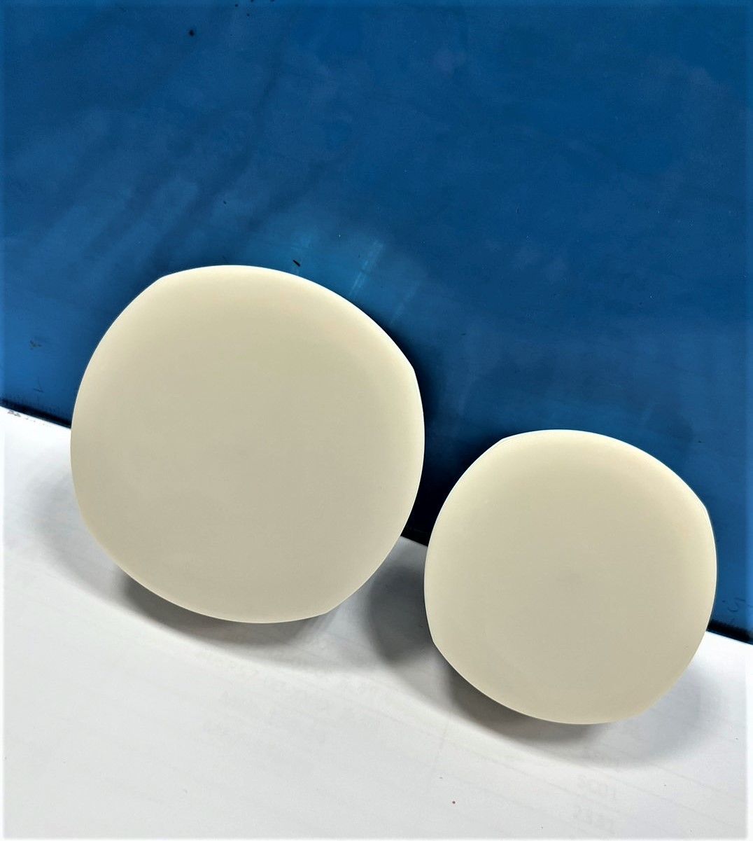 Two white circles are sitting on a white surface.